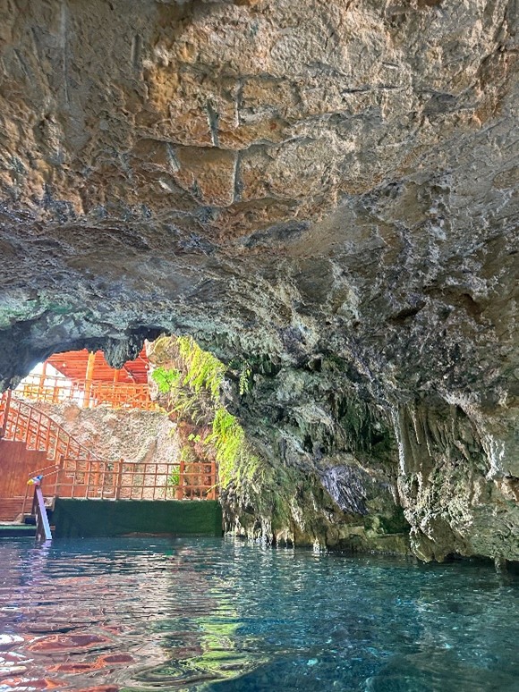 The inside of a cave with waist deep water.