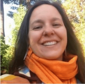 a light skinned woman with long brown hair smiling outside