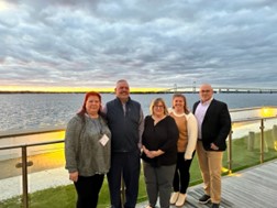 Claudia Cortes, Rob Hyde, Sue Cone, Christine Escobedo, and Brian Girard posing in front of the water