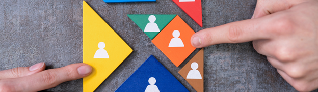 Triangle and square puzzle pieces in different colors that have a persons profile outline being put together.