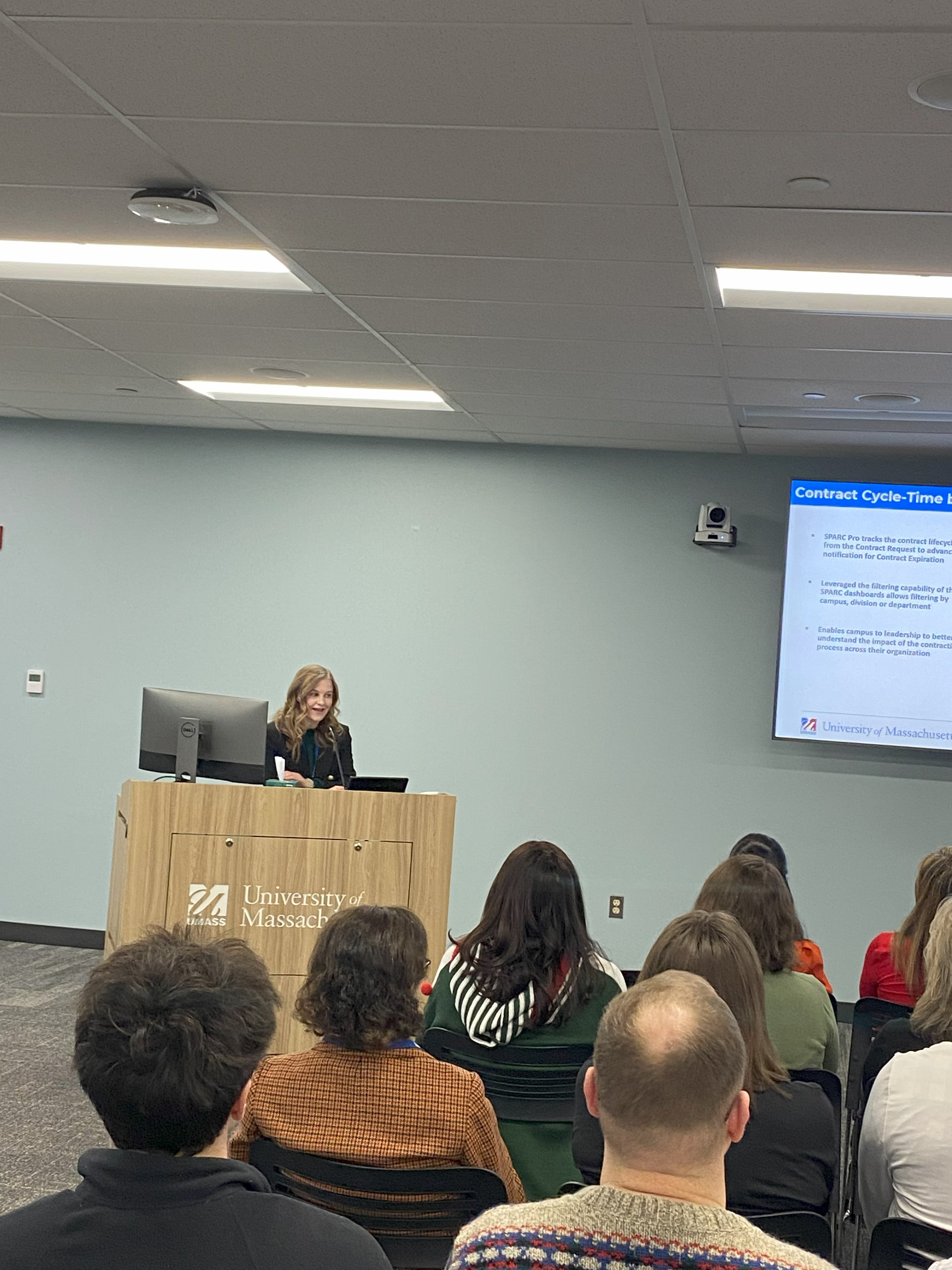 Anne Zuev presenting to a group in front of a large screen