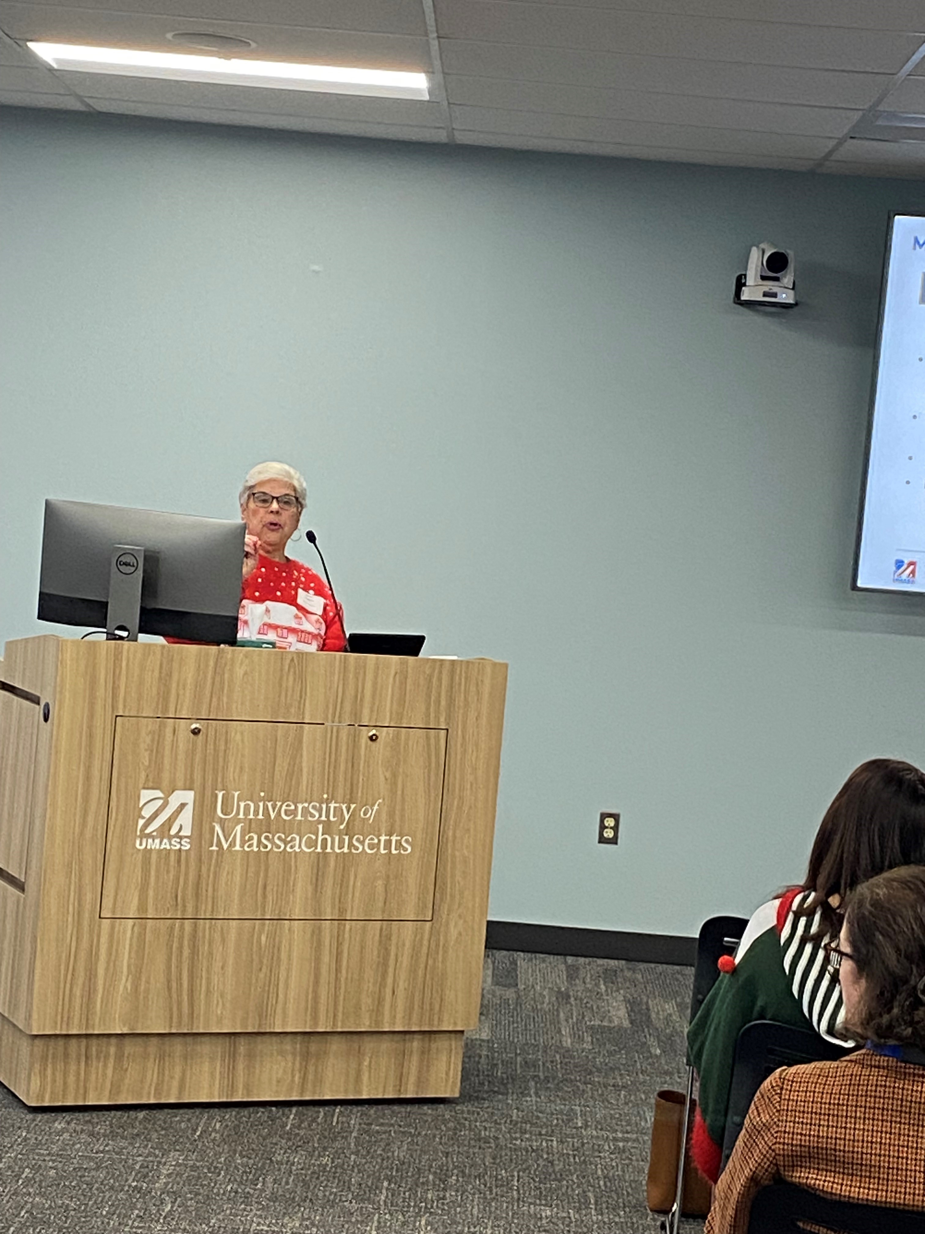 Carol Dugard presenting to a group behind a podium