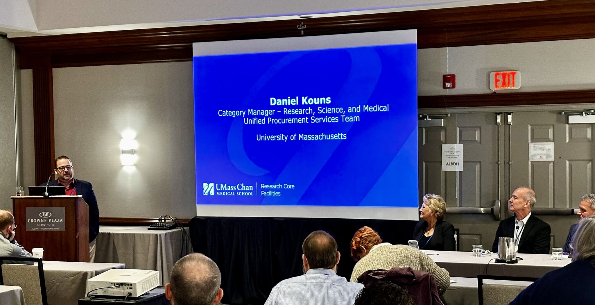 Daniel Kouns at a podium in front of a presentation
