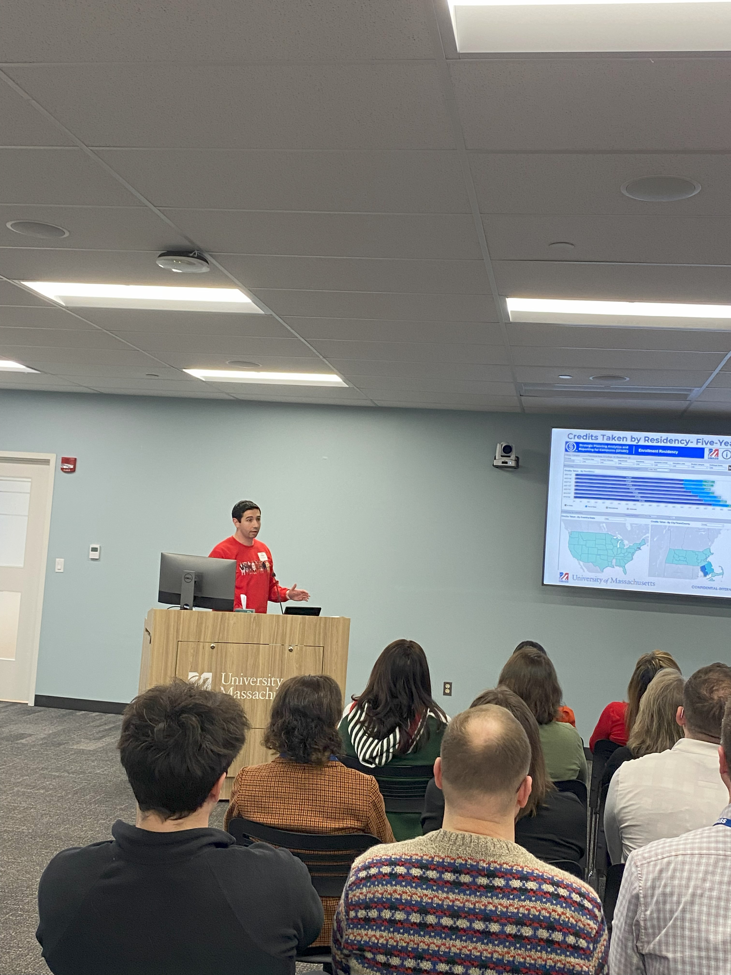 Eric Gregoire presenting to a group in front of a large screen