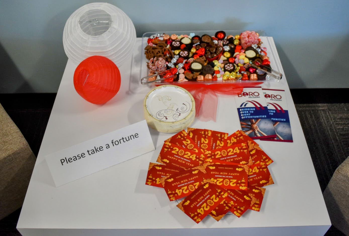 A table with candy and fortune cards. A sign says, "Please take a fortune."