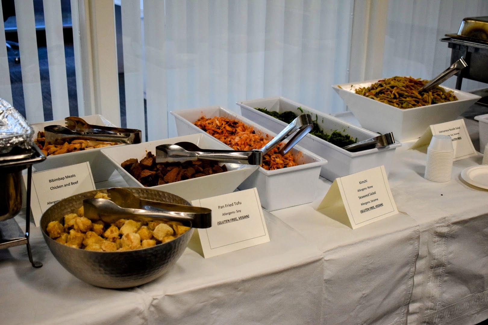 A serving table with various plates of food.