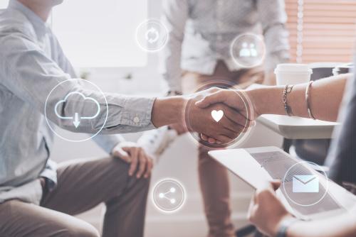 Two people shaking hands in an office setting with digital icons for cloud computing, customer feedback, email, and collaboration overlaying the image.