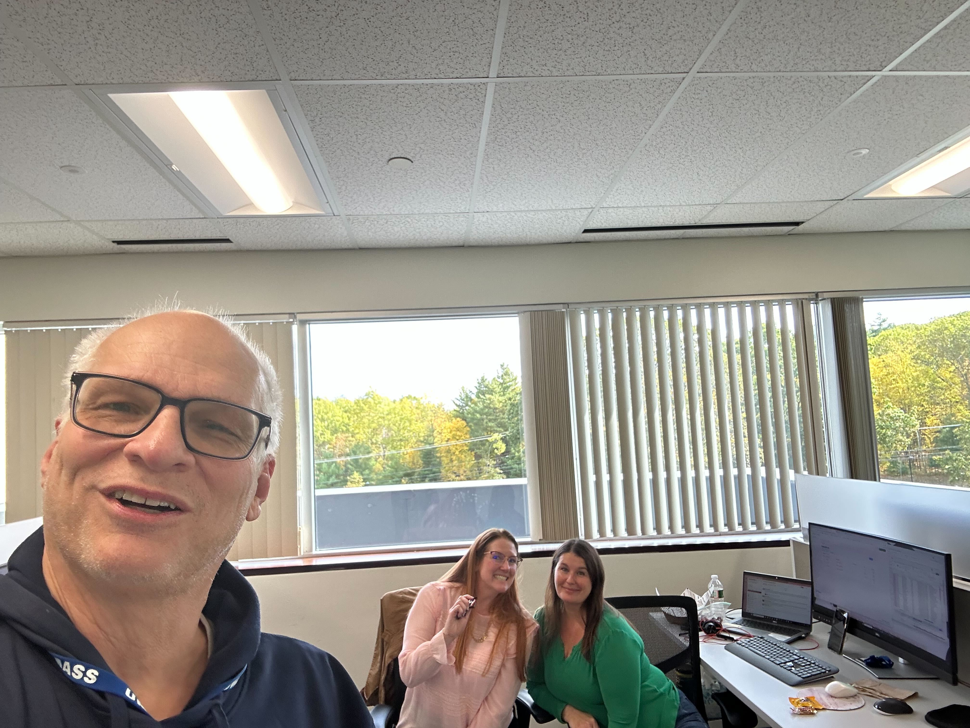 two women with candy smiling and a man smiling in front of them