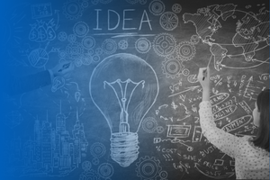 Chalkboard with brainstorm session of images and text surrounding a chalk drawn lightbulb and the word idea.
