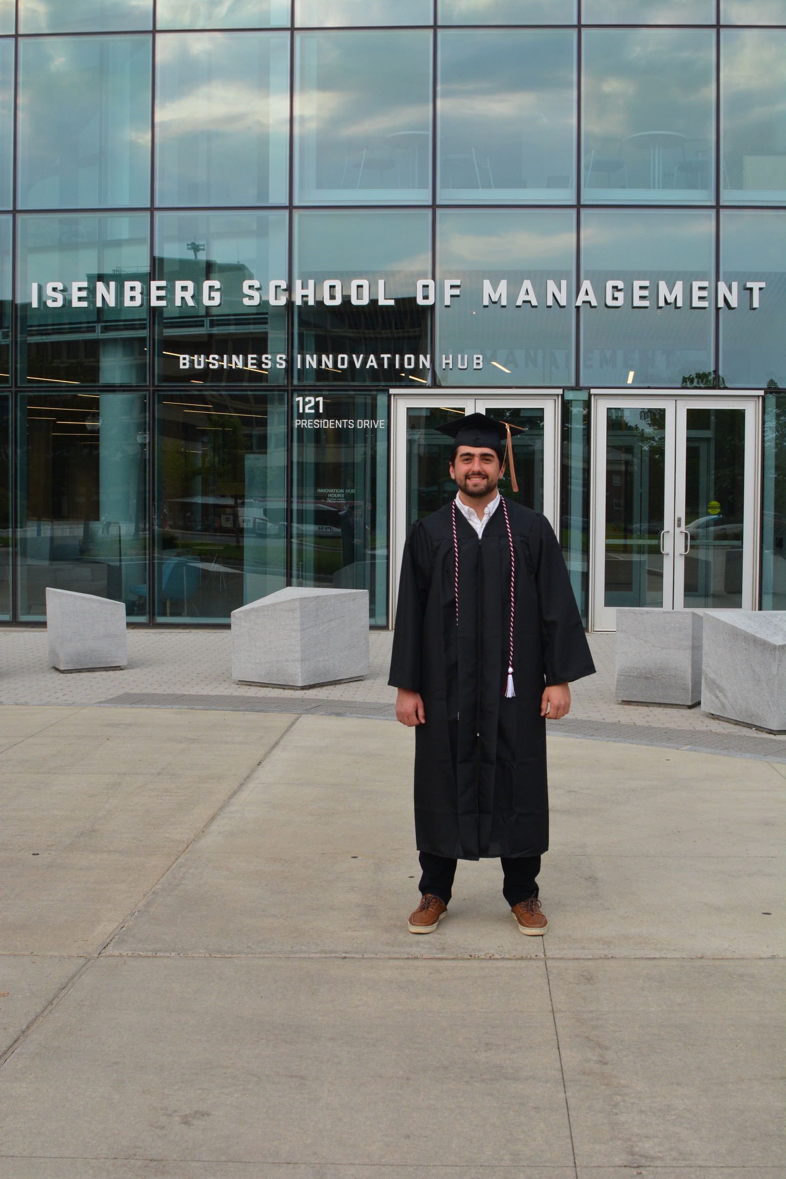 Male smiling wearing graduation cap and gown