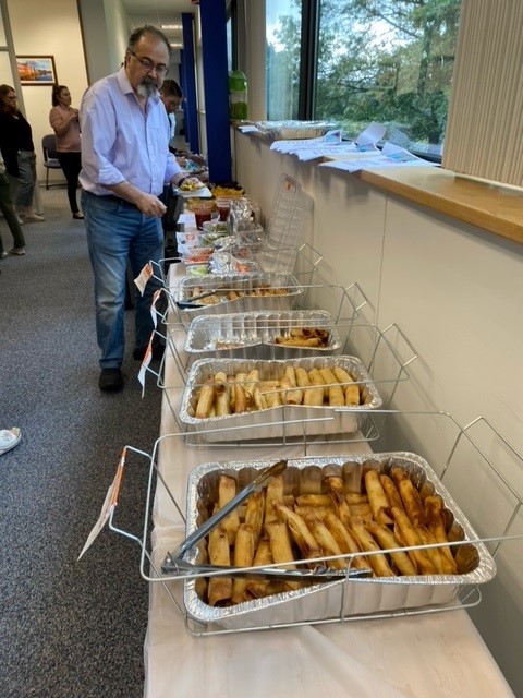 Man going through buffet with trays of taquitos