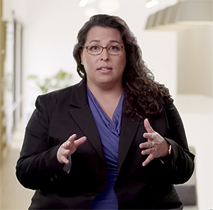 Melissa Doman, a white woman with long hair talks as she gestures with her hands.