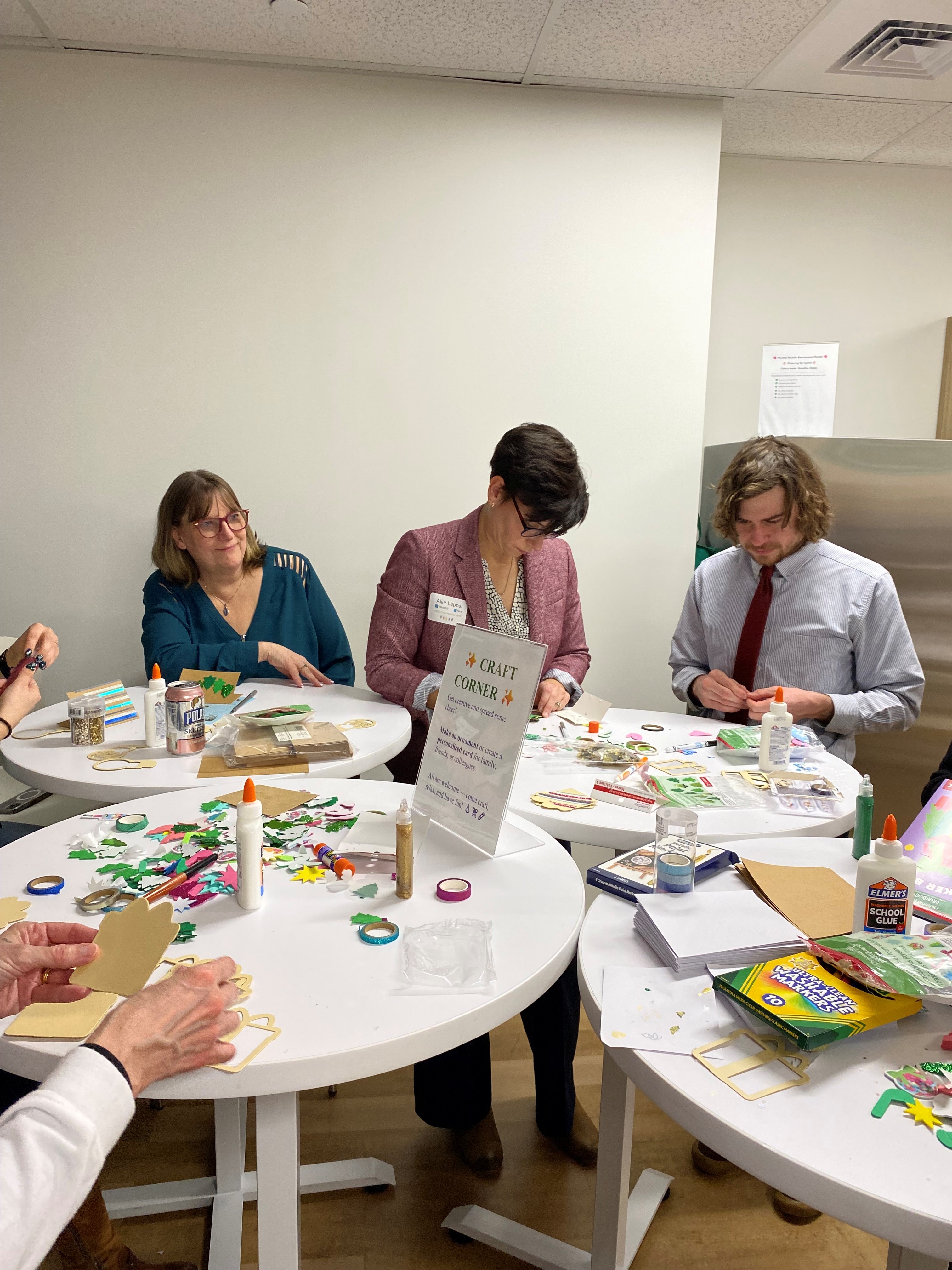 A group of employees around a table making holiday crafts