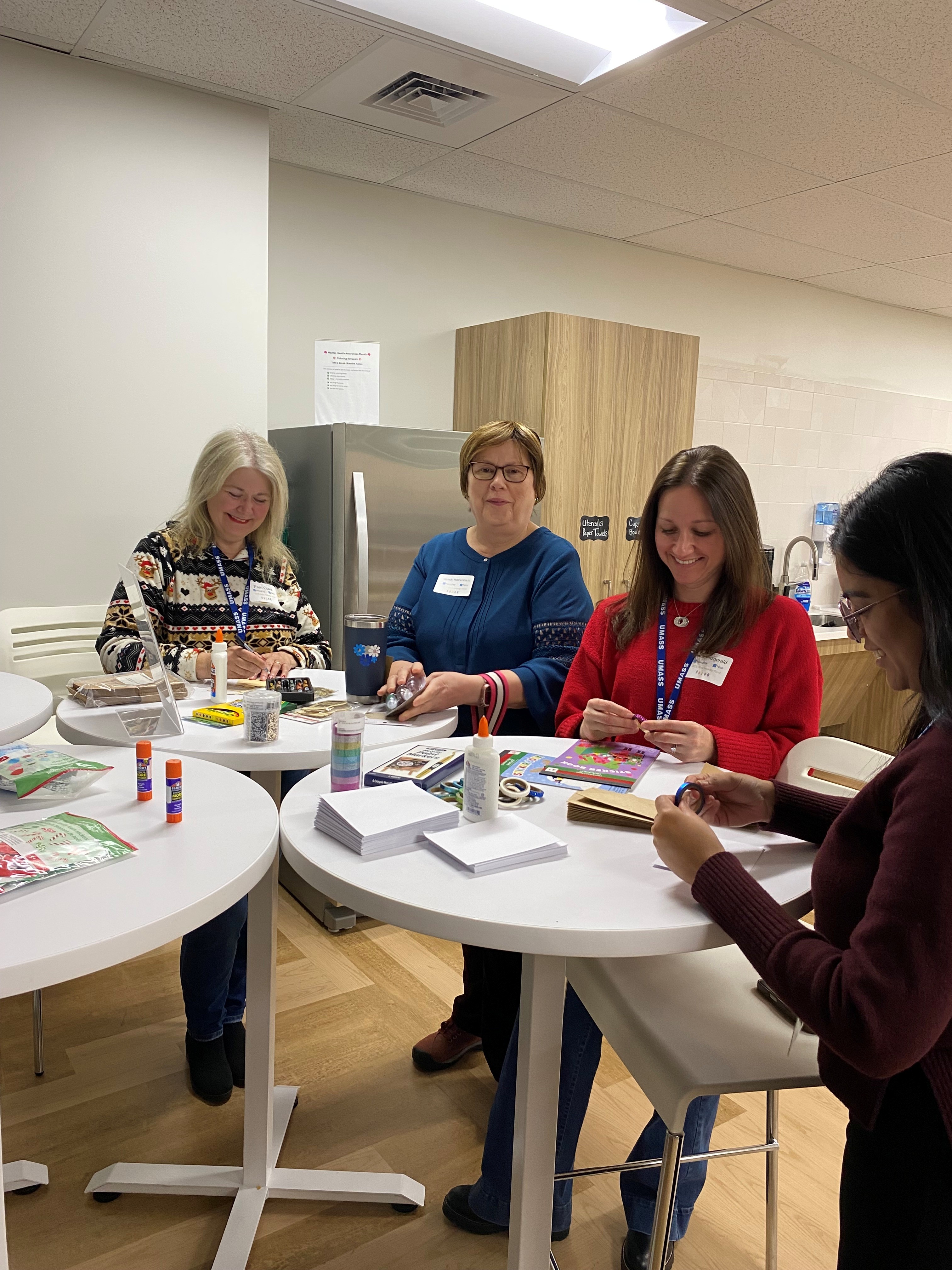A group of employees around a table makig holiday crafts