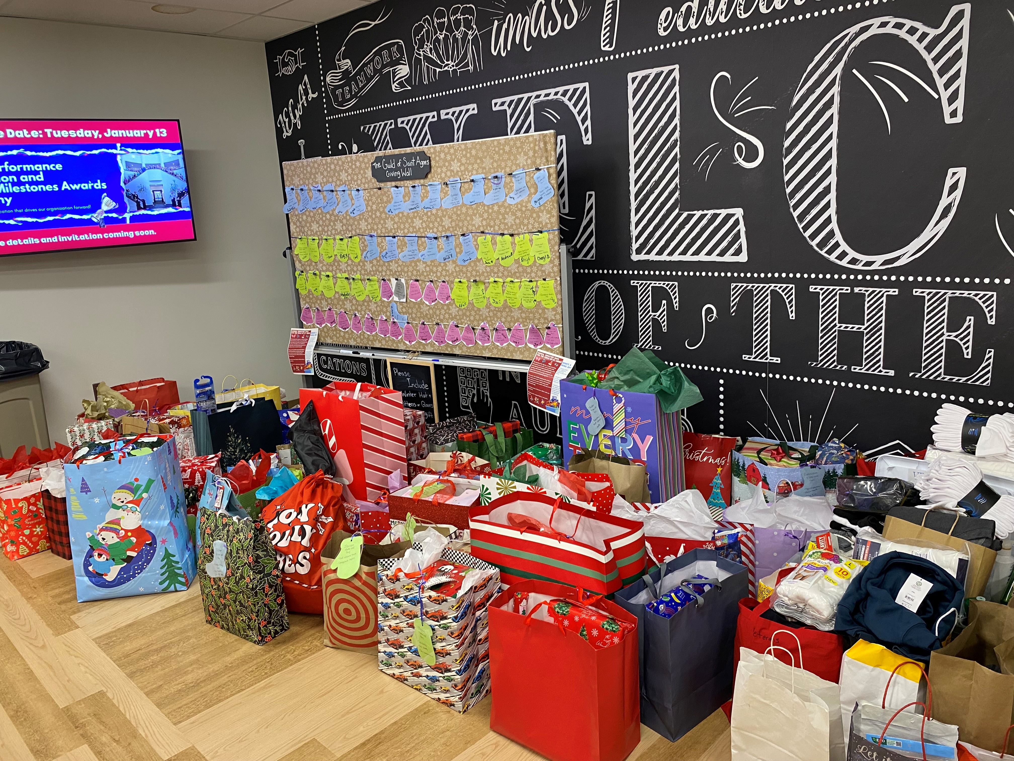 A large pile of wrapped presents to send to a school for children
