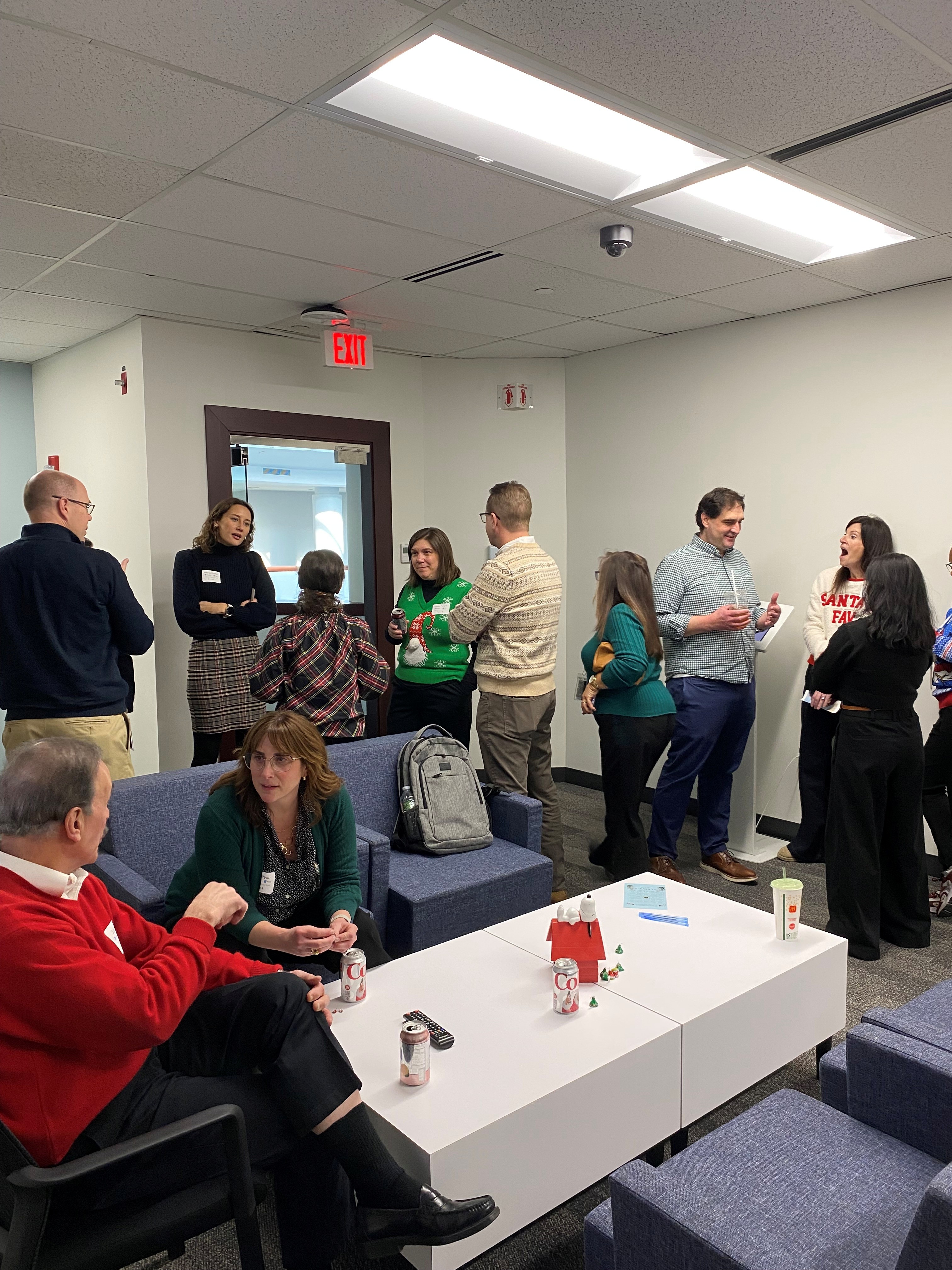 A group of colleagues standing together and socializing at a holiday part