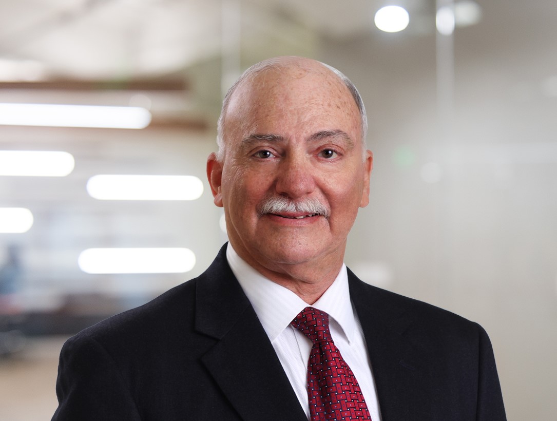 male in suit with red tie smiling