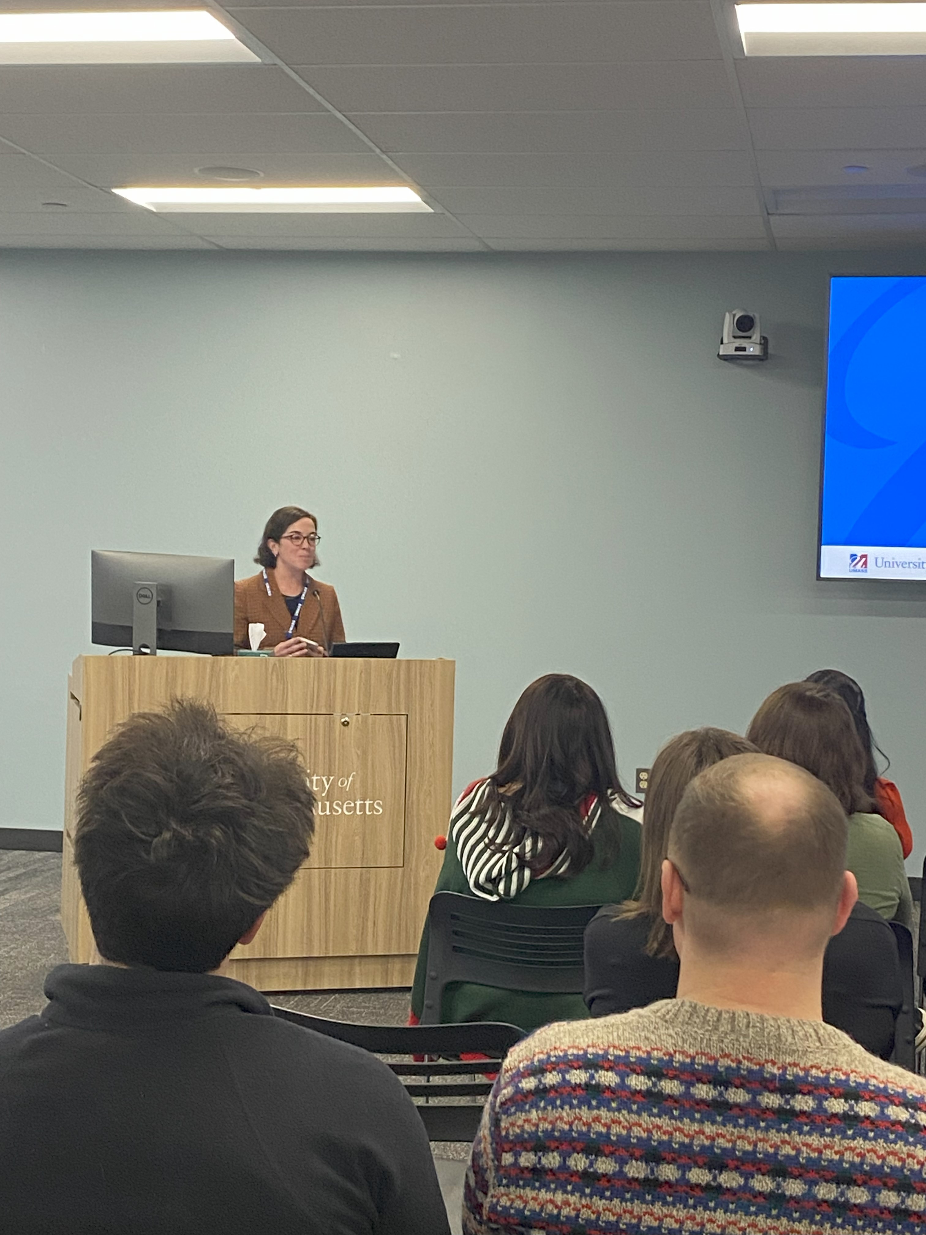 Lisa Calise presenting to a group from a podium