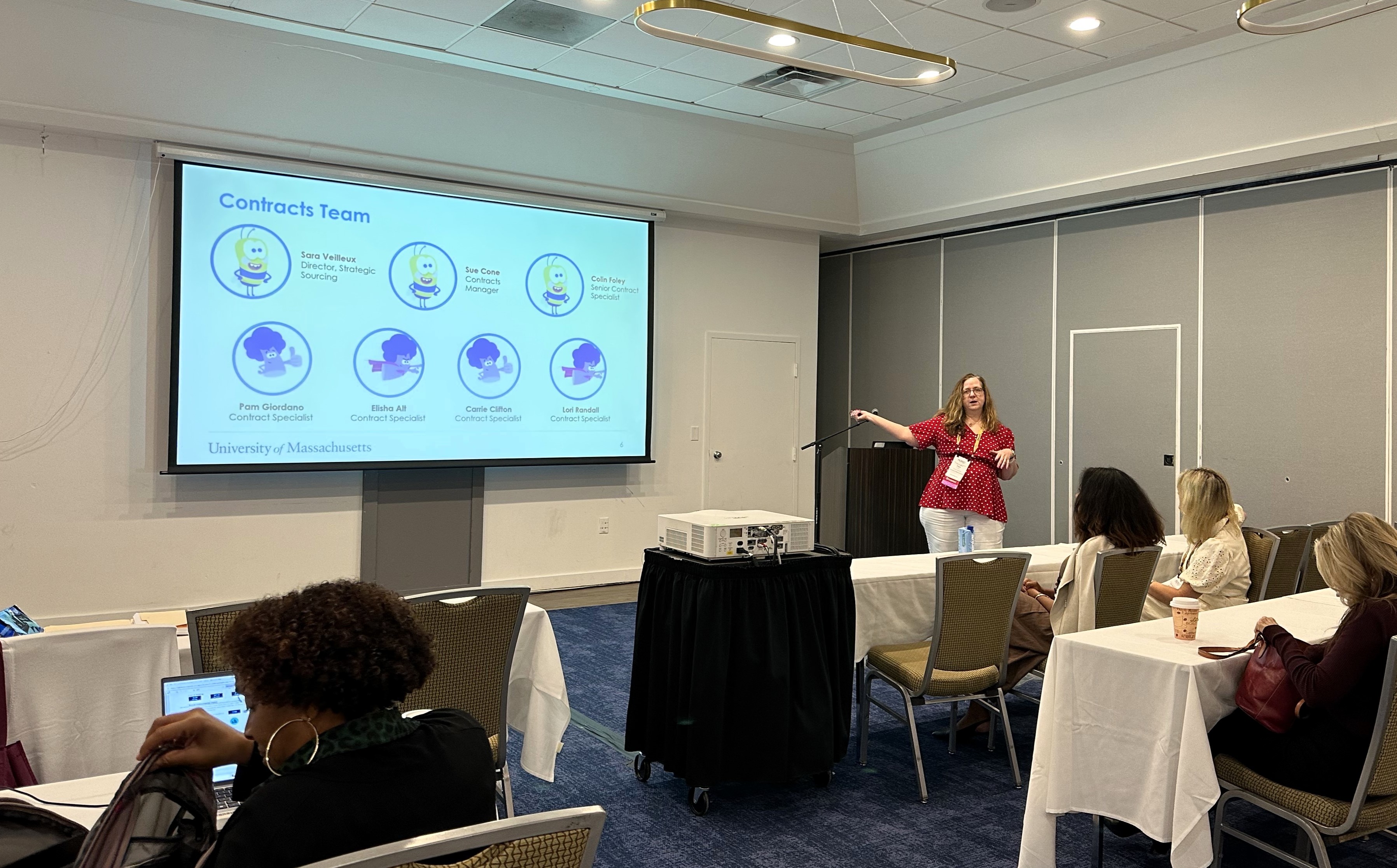 Pam Giordano presenting in front of a powerpoint that says Contracts Team