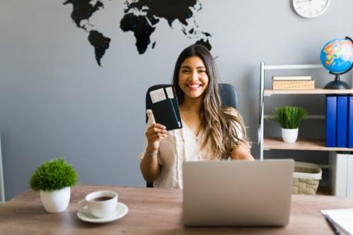 person holding passport in front of laptop