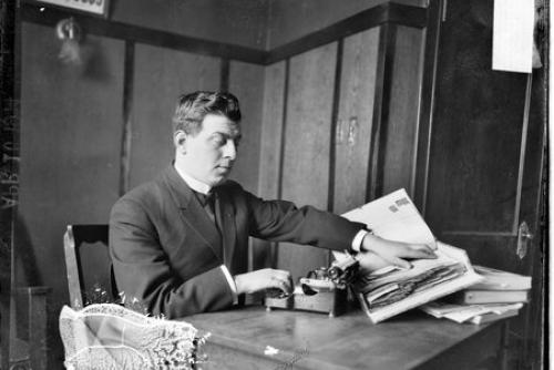 Jacob Bolotin, a light-skinned man, runs his fingers along book in braille.