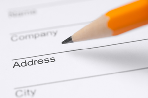 Close up of pencil filling out a form with fields that say name, company, address