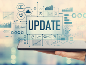 Hand holding a laptop with an overlay of icons and the word update