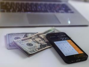 iphone calculator open with cash beside it