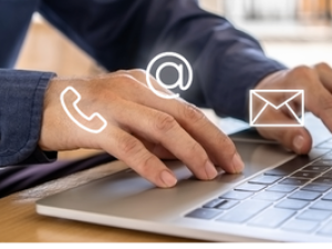 Closeup of hand typing on a keyboard with icons for a phone and email