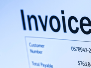 Closeup of a piece of paper with the word Invoice written at the top