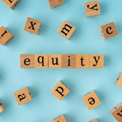 The word equity spelled out with wooden blocks.