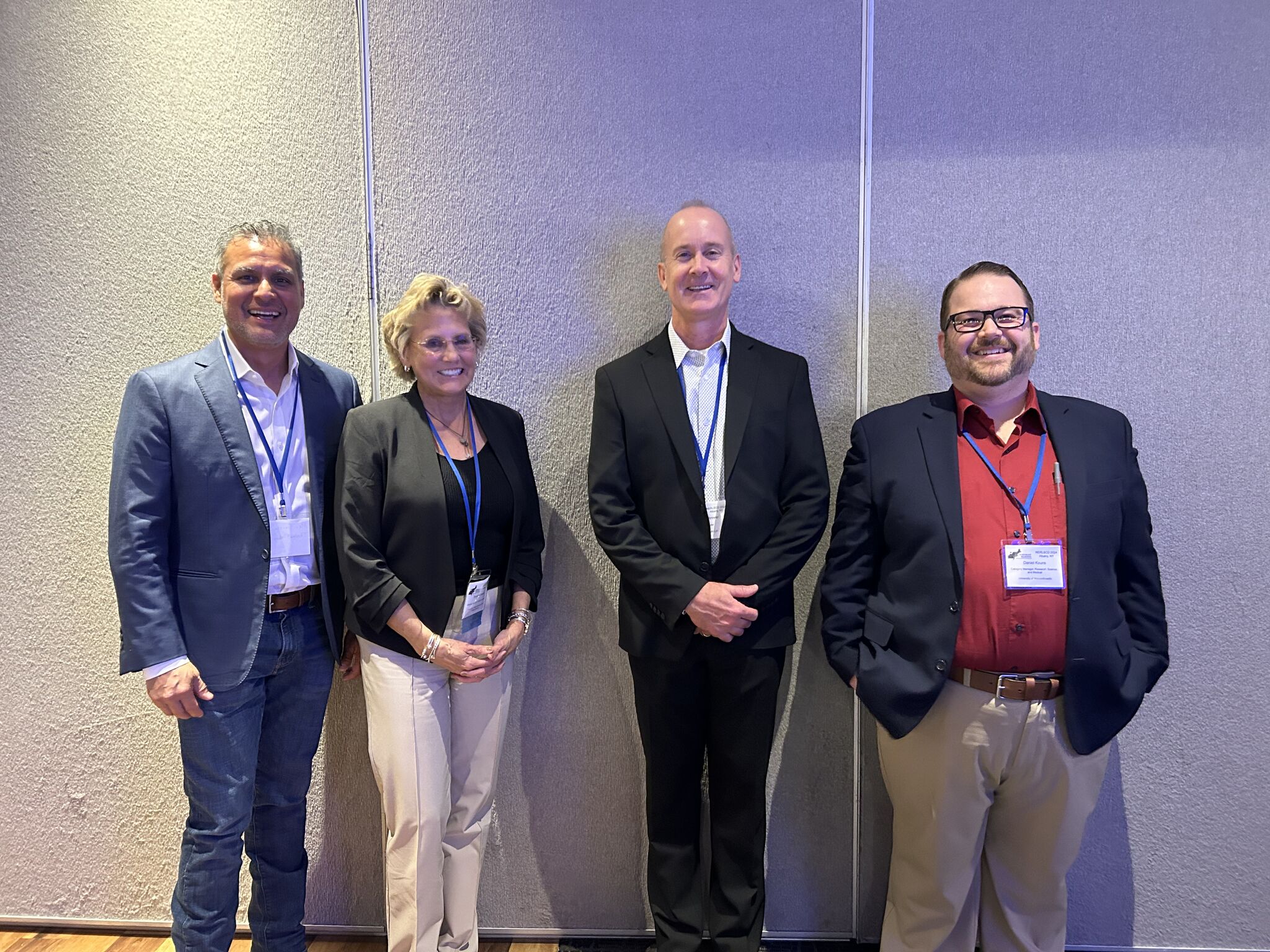 Four people posing at a conference